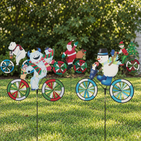 Five Christmas bike spinners, a polar bear, yeti, Santa, snowman and elf, staked in a front lawn